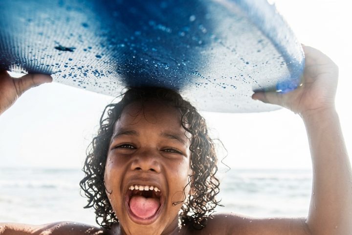 Menino com prancha de bodyboard infantil